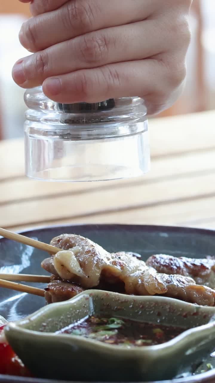 persona que condimenta los alimentos con un batidor de sal