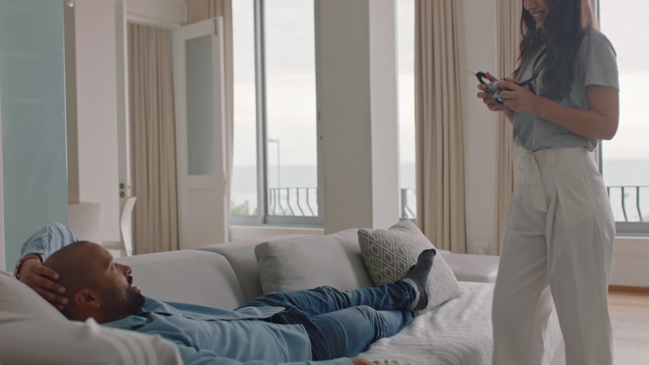 행복한 커플이 카메라를 사용하여 함께 사진을 찍고 재미있게 소파에서 집에서 휴식을 취하고 로맨틱한 관계를 즐기며 서로 놀이적으로 사진을 찍고 있습니다.