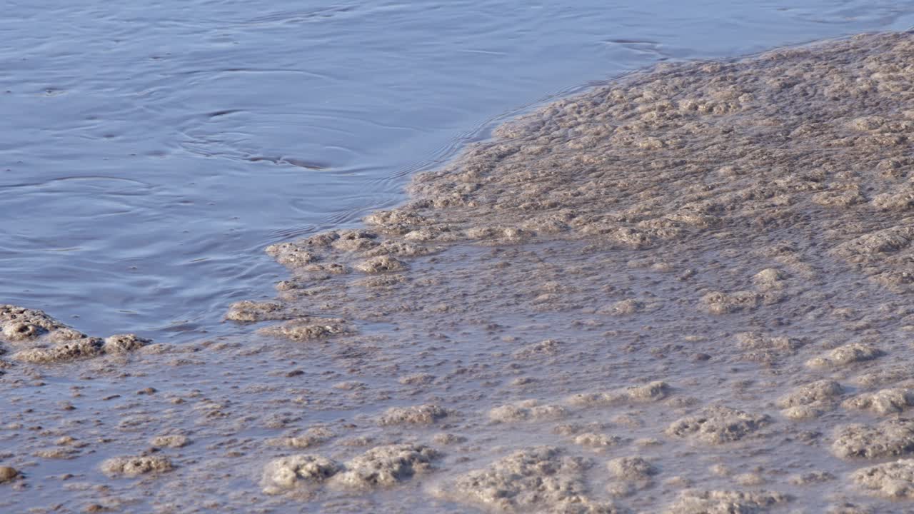Close-up of aeration process with foam in wastewater treatment, representing cleansing, industrial environment.