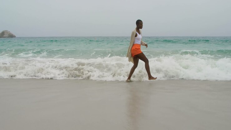Giovane donna afroamericana che balla sulla spiaggia 4k