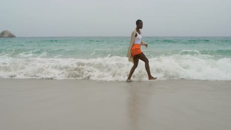 joven mujer afroamericana bailando en la playa 4k