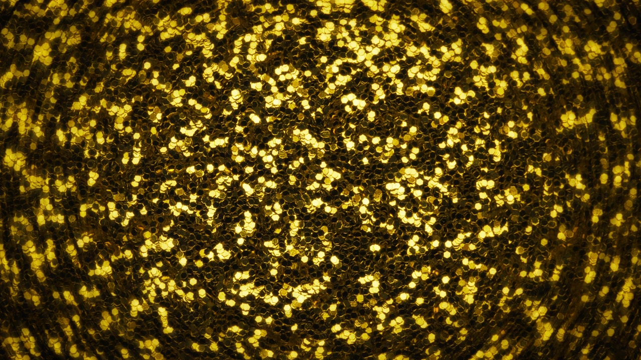 Golden glitter fading out into black. Abstract background