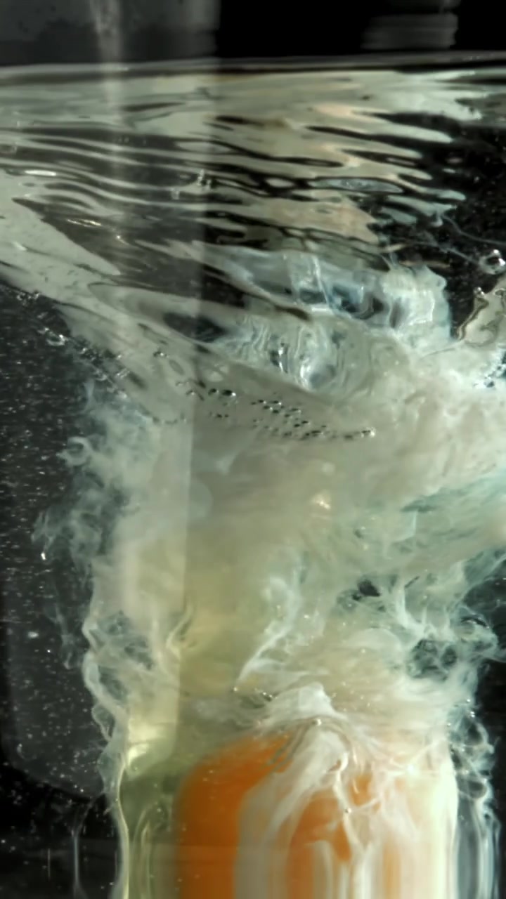 Close-up of a Raw Egg Yolk and White Spreading in Water
