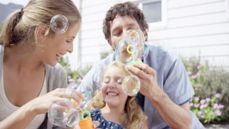 Happy-family-blowing-bubbles-in-the-yard-at-home