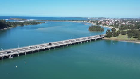puente de windang sobre el estuario que conecta el lago illawarra con el océano pacífico en un día soleado, aérea
