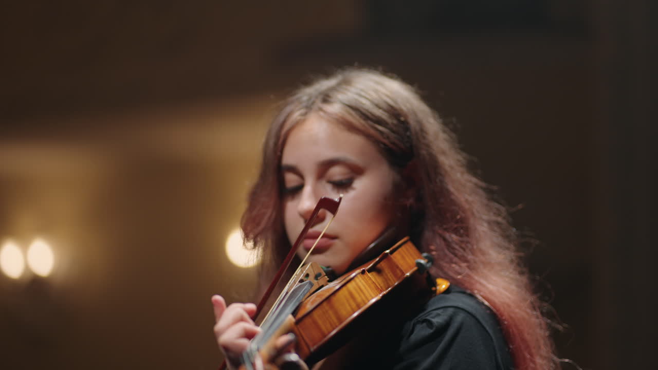 una bonita violinista está tocando el violín en el salón de música retrato de una violinista en la casa de la ópera