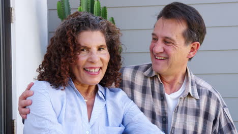 retrato de una pareja de ancianos sonrientes relajándose fuera de casa con una bebida caliente