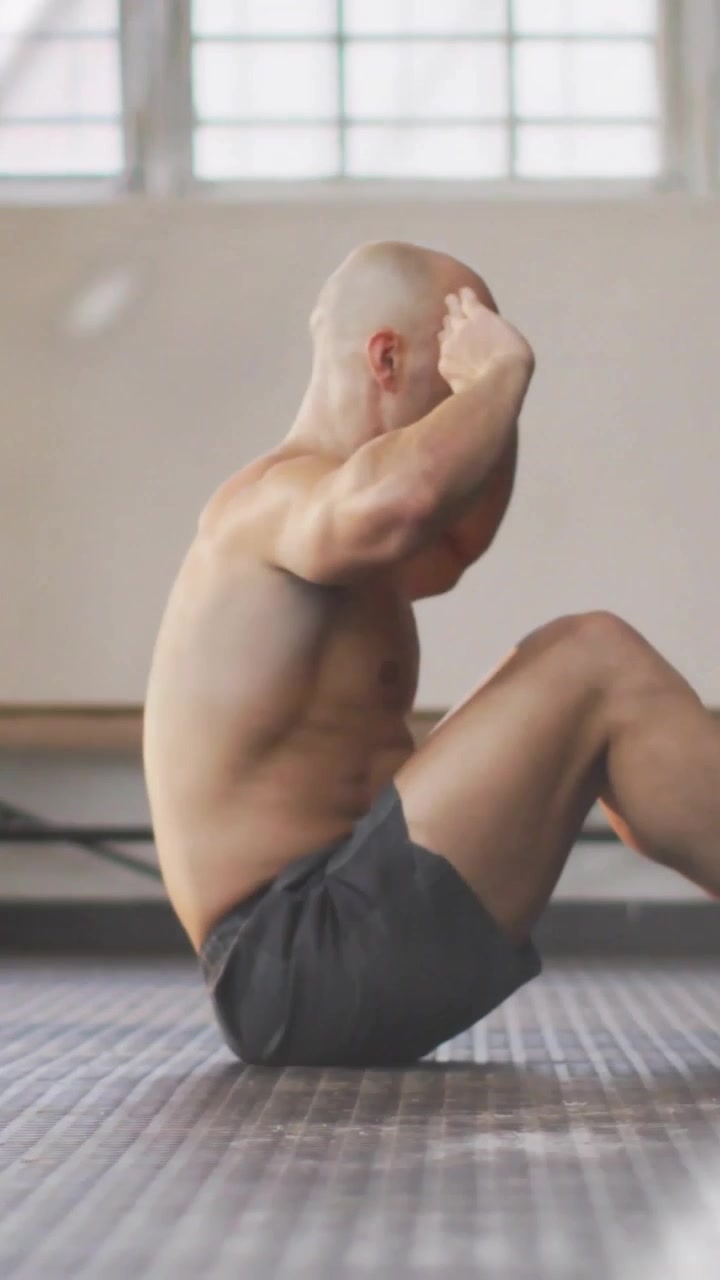 Video verticale: Uomo che contrae gli addominali e ripete i crunch per il fitness con una sovrapposizione color verde acqua che attraversa il corpo