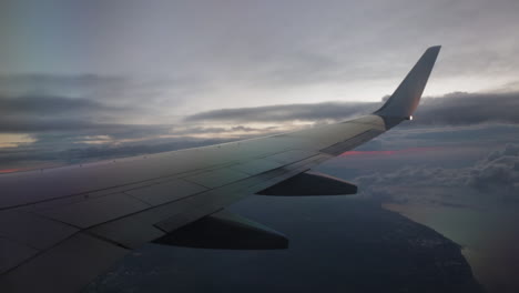 Beginning-of-sun-rise-view-from-airplane,-wing-in-view