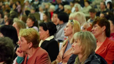 crowd of people to sitting and listening in a large hall