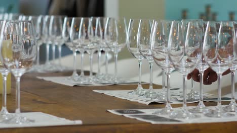 Waiter setting wine glasses on table for wine tasting, low perspective static shot