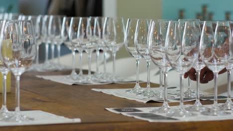 waiter setting wine glasses on table for wine tasting, low perspective static shot