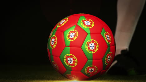 jugador de fútbol pateando la pelota de la bandera de portugal