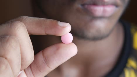 person holding a pink pill