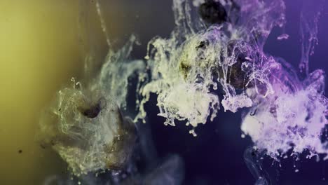 black and purple paint ink exploding underwater with yellow background light