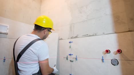 worker installing tiles on a wall during home renovation