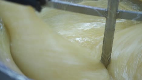 close-up of a vat of turkish delight at the factory as a worker adds the flavoring