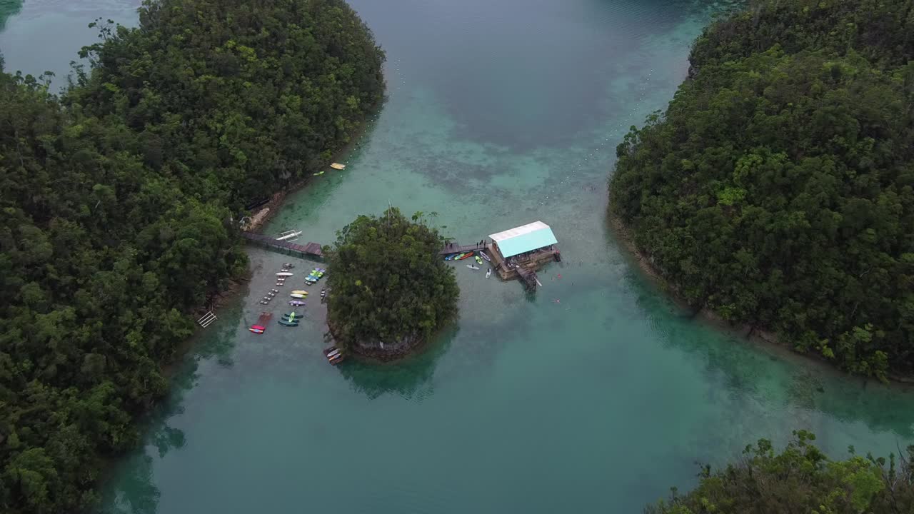 Holidaymakers kayaking and swimming at pontoon-style lodge of Sugba lagoon on Siargao island