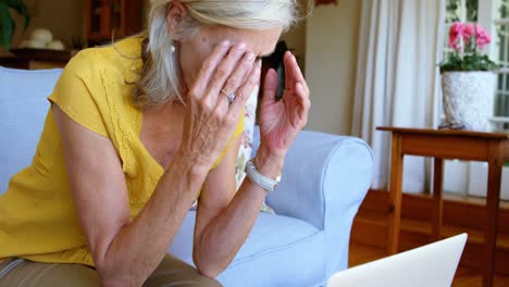 worried senior woman sitting on sofa at home 4k