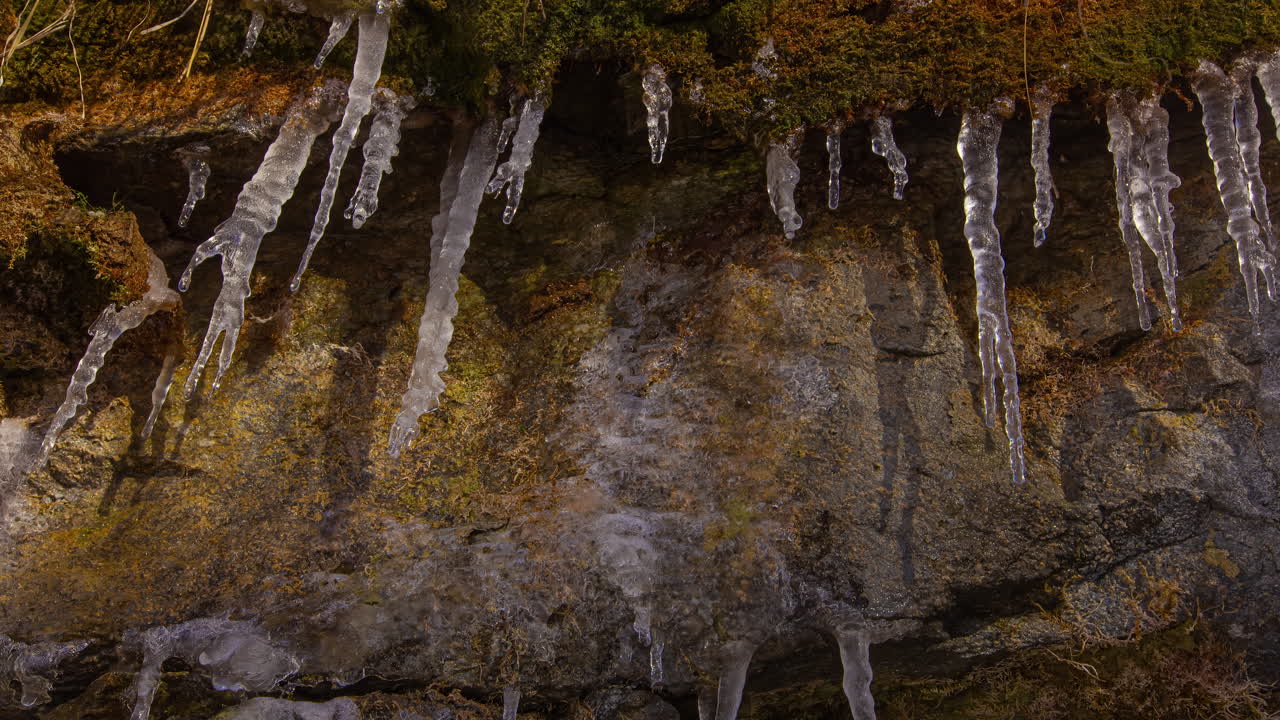 astillas de hielo en una pared de piedra con musgo