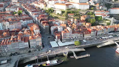 drone shot flying down and panning up with river in view in porto portugal at sunset