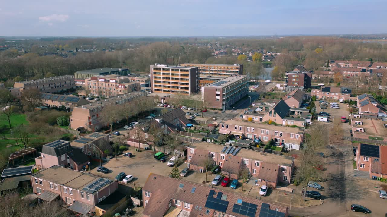 Ampia vista aerea che mostra una zona residenziale diversificata a Nijmegen, Paesi Bassi. Un mix di case e condomini con pannelli solari indica uno sviluppo urbano sostenibile