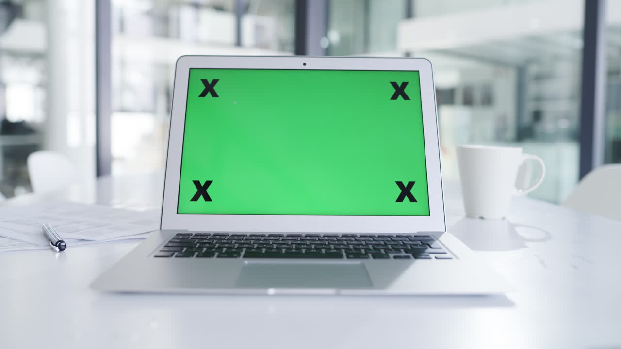 portátil con pantalla verde en la oficina