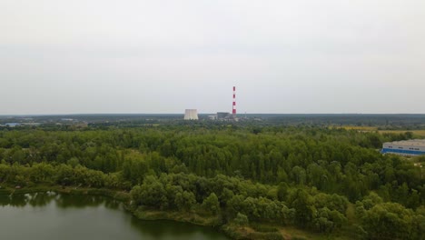 Aerial-view-over-a-river-and-forest,-towards-the-TES-6-coal-power-plant,-cloudy-day,-in-Kiev,-Ukraine---dolly,-drone-shot