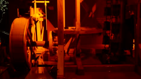 vista artística de un modelo tradicional de molino de agua amarillo con una rueda de madera giratoria con cuchillas, corriente de agua que cae, un conjunto de engranajes y postes