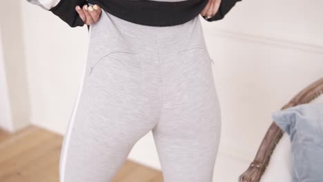 figura femenina vistiendo pantalones deportivos grises. imágenes en interiores. primer plano