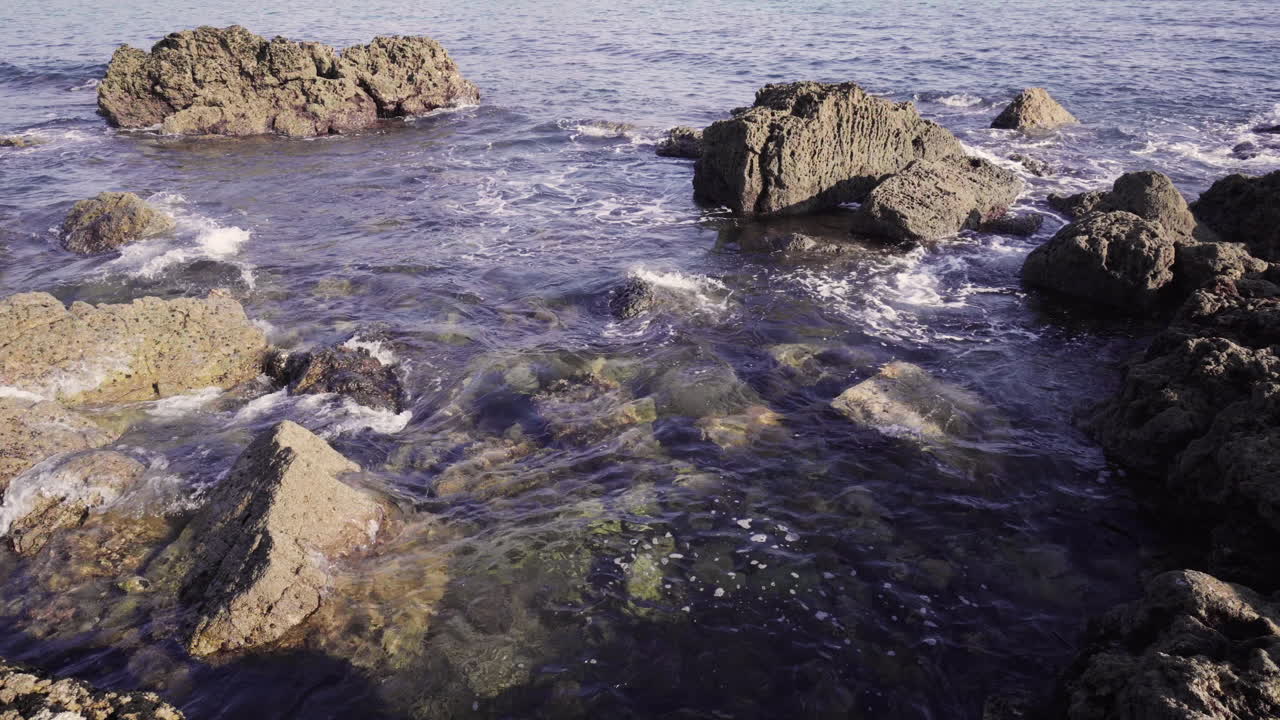 Acqua azzurra che si muove tra le rocce in Algarve, Portogallo