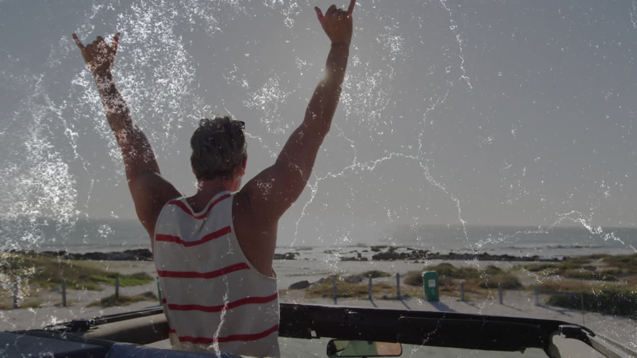 Man raising arms in convertible on coastal road, with animated business data chart and map pin