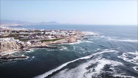 Panoramic-drone-shot-of-the-blue-ocean-and-beach-houses-in-Peru