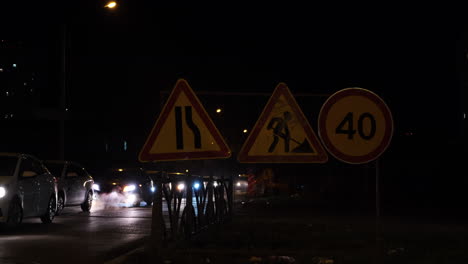 road work at night with traffic and speed limit signs