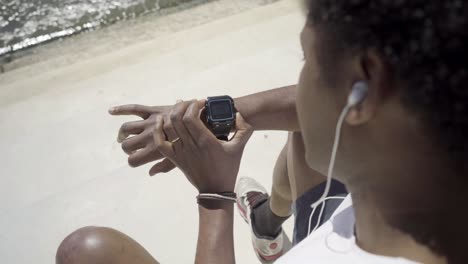 focused african american man setting sport watch