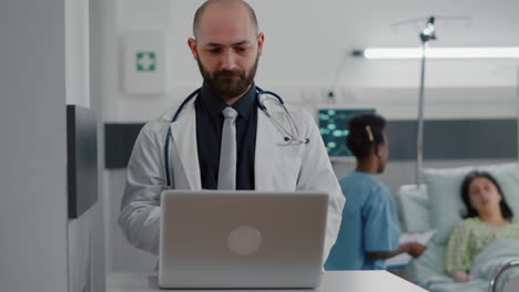 Front-view-of-practitioner-doctor-typing-illness-expertise-on-computer