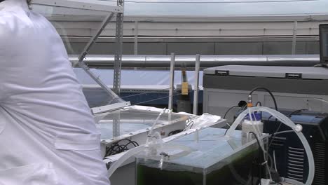 dolly moving from one scientist working with a flat panel towards other flasks where we discover another scientist in the background
