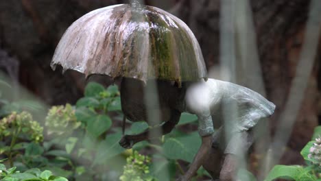 art installement of a girl holding an umbrella in the rain at the gardens by the bay in singapore