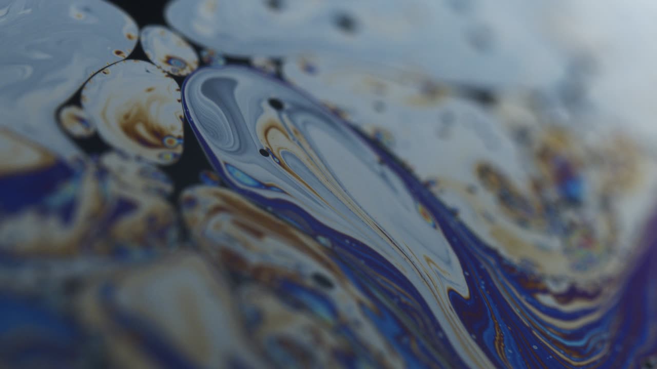 superficie de la película de jabón con círculos de forma irregular y remolinos curvos