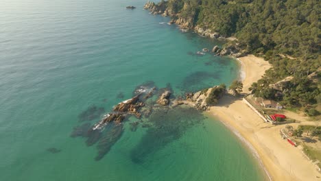 Aerial-view-of-beautiful-exotic-empty-rocky-beach-with-golden-sand-in-Spain