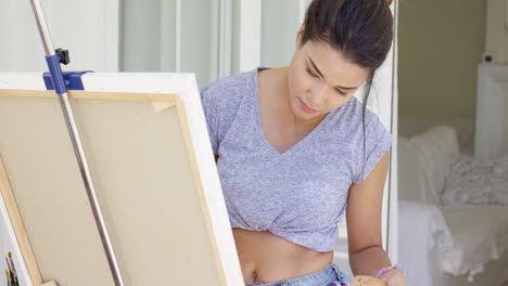 joven artística trabajando en una pintura
