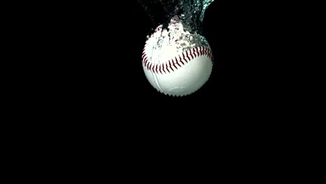 baseball falling in water on black background