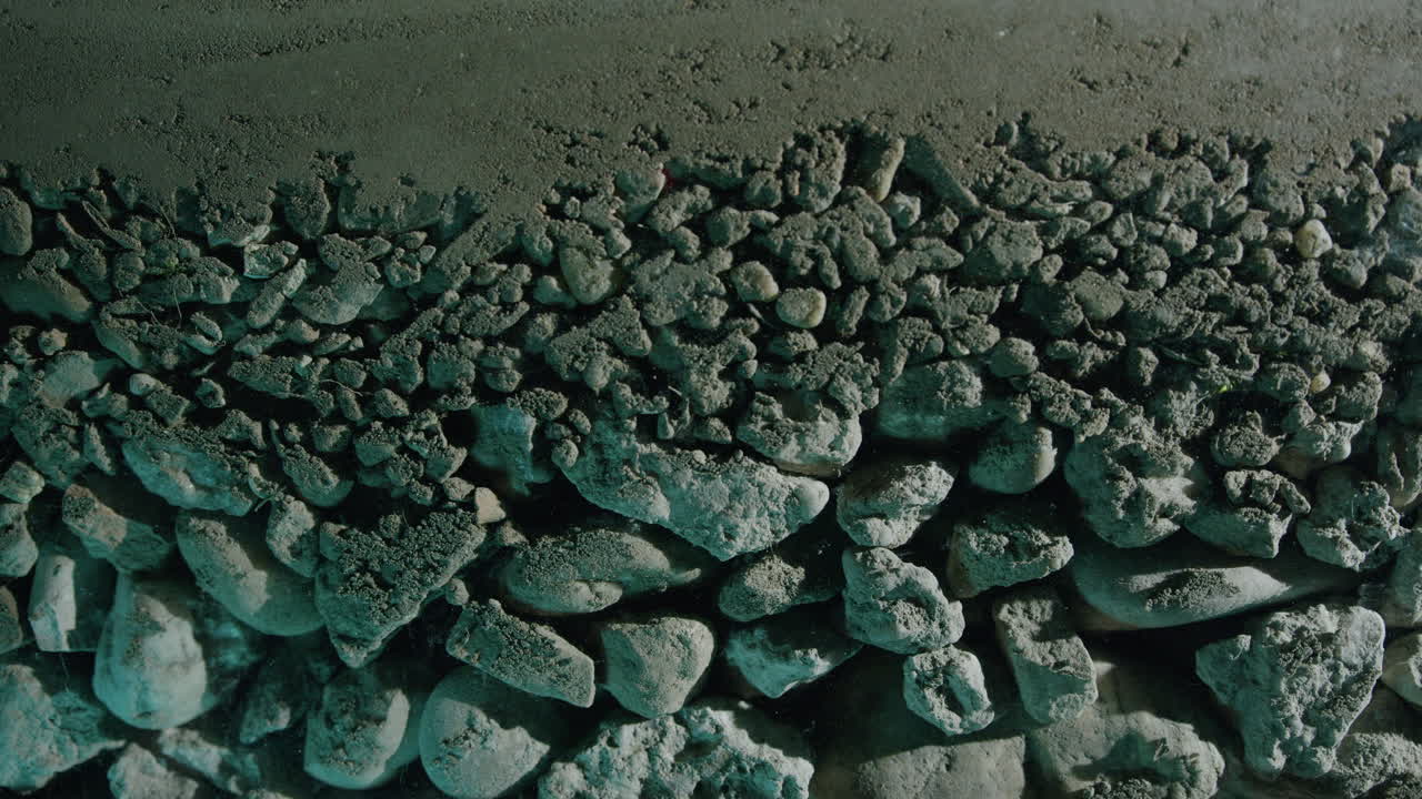 Moving slider Close-up shot of layered sand rocks and pebbles underground