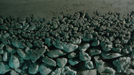 moving slider close-up shot of layered sand rocks and pebbles underground