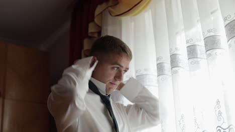 Handsome-groom-wears-a-tie-Wedding-morning.-Businessman.-Slow-motion