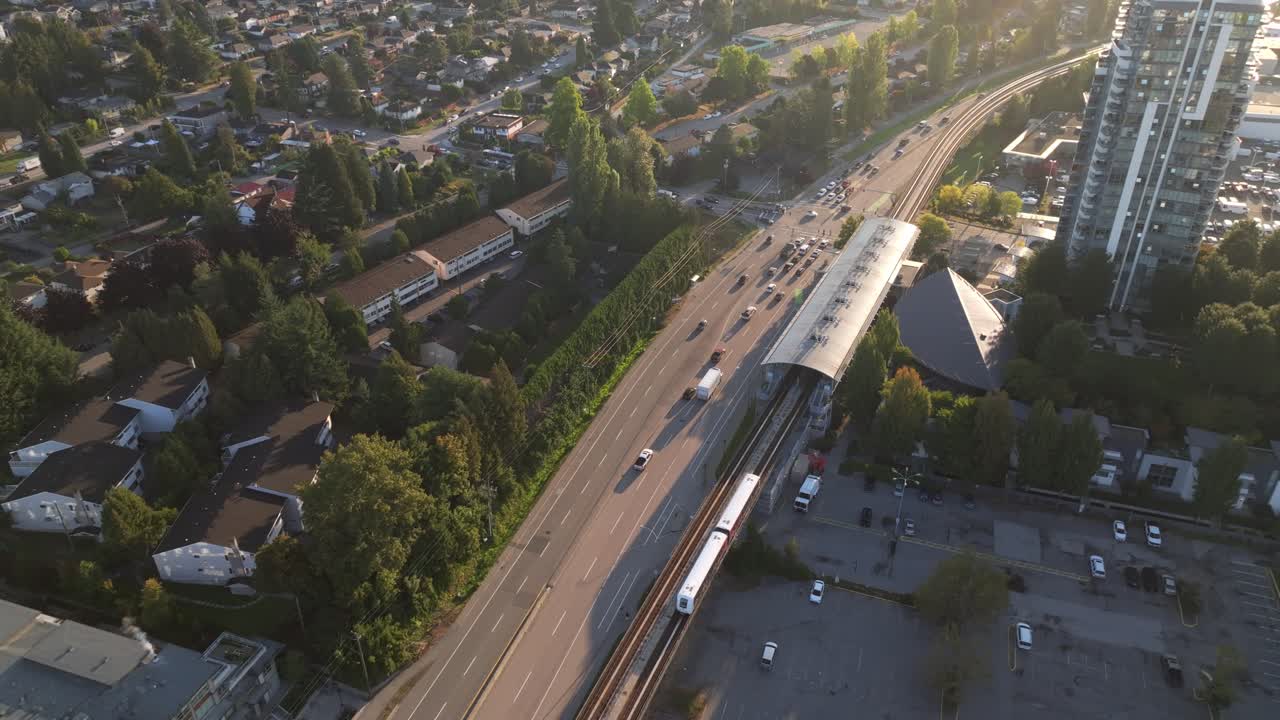 Hareketli yollar, hızlı toplu taşıma hattı ve yüksek binalarla güneşli bir sabahta Burnaby, Kanada şehir manzarası. hava çekimi