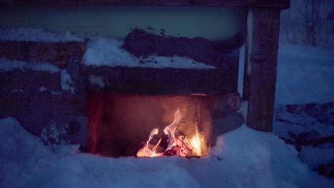 firewood is burning beneath the diy hot tub to provide heat - close up