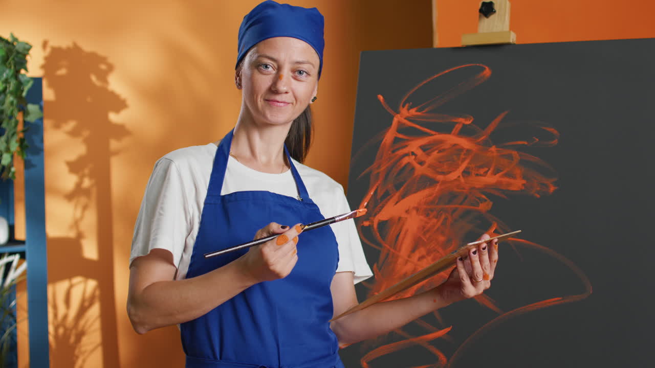 Female artist painting abstract art in studio