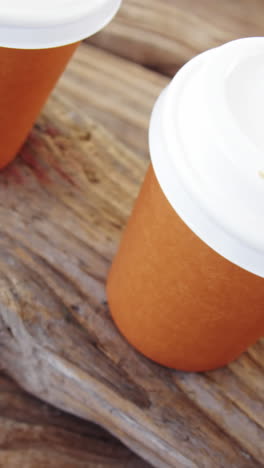 taza desechable en una fila en una tabla de madera