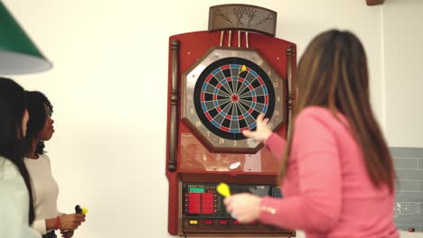group of multi-ethnic friends playing darts at home